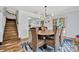 Dining room with wooden table, wicker chairs, modern chandelier, and a view into the kitchen at 612 Montezuma Dr, Bradenton, FL 34209