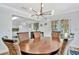 Dining room with a wooden table and chairs, an elegant light fixture, and an open view of the kitchen at 612 Montezuma Dr, Bradenton, FL 34209