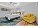 Bright main bedroom with hardwood floors, a ceiling fan, and a cozy yellow chair at 612 Montezuma Dr, Bradenton, FL 34209