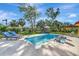 Inviting backyard pool featuring stylish lounge chairs and serene outdoor dining beneath a bright, sunny sky at 612 Montezuma Dr, Bradenton, FL 34209