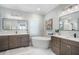 Modern bathroom boasts double vanity sinks, garden tub, marble floors, decorative mirrors, and great lighting at 6411 Grenada Island Ave, Apollo Beach, FL 33572