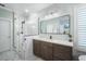 Bathroom features glass shower, double sink vanity, marble floors, modern fixtures, and a large mirror at 6411 Grenada Island Ave, Apollo Beach, FL 33572