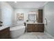 Bright bathroom featuring a soaking tub, marble tile and wooden cabinets at 6411 Grenada Island Ave, Apollo Beach, FL 33572