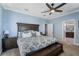 Large primary bedroom boasts blue walls, ceiling fan, neutral carpet, and an en suite bathroom at 6411 Grenada Island Ave, Apollo Beach, FL 33572