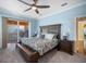 Bright primary bedroom with ceiling fan, blue walls, carpeted floors, and sliding doors to a patio at 6411 Grenada Island Ave, Apollo Beach, FL 33572