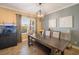 Bright dining room boasts modern chandelier, neutral wall colors, and a beautiful hardwood dining table at 6411 Grenada Island Ave, Apollo Beach, FL 33572