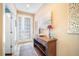 Warm and inviting foyer featuring a decorative table, art, and tiled flooring at 6411 Grenada Island Ave, Apollo Beach, FL 33572