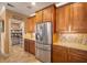 Kitchen featuring stainless steel refrigerator, wood cabinetry, granite counters, and walk in pantry at 6411 Grenada Island Ave, Apollo Beach, FL 33572