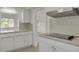 Bright kitchen area featuring white cabinets and tile countertops plus stainless steel vent hood at 6655 Colony S Dr, St Petersburg, FL 33705