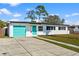 Charming single-story home with a well-manicured lawn and a bright blue door and garage at 6681 32Nd N Ave, St Petersburg, FL 33710