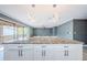 Modern kitchen island features granite countertops, white cabinets, and statement lighting with an open concept to the living area at 722 116Th Ave N # 2002, St Petersburg, FL 33716