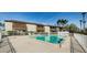 Community pool area with poolside seating, surrounded by tropical trees at 722 116Th Ave N # 2002, St Petersburg, FL 33716