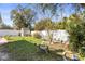 Backyard with green grass, trees, a shed, and a white fence at 8208 Harwich Port Ln, Gibsonton, FL 33534