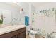 Well-lit bathroom with a vanity, toilet, and shower featuring a decorative, leafy shower curtain at 8208 Harwich Port Ln, Gibsonton, FL 33534