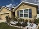 Well-maintained front exterior with stone-lined flower bed and manicured bushes at 8208 Harwich Port Ln, Gibsonton, FL 33534