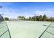 Well-maintained outdoor tennis court with a net and fencing, ready for a match at 8208 Harwich Port Ln, Gibsonton, FL 33534