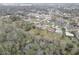 Aerial view of houses in a neighborhood surrounded by lush greenery and mature trees at 8547 Horizon Ln, Hudson, FL 34667