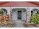 Inviting entrance with decorative metal gate, arched openings, and exterior sconces at 8547 Horizon Ln, Hudson, FL 34667