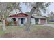 Charming single story home with mature trees, a red trim and a spacious driveway leading to an attached garage at 8547 Horizon Ln, Hudson, FL 34667