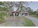 Charming single story home with mature trees, a red trim and a spacious driveway leading to an attached garage at 8547 Horizon Ln, Hudson, FL 34667