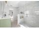 The renovated bathroom has a glass shower and sage green vanity with white countertop at 8814 Hampden Dr, Tampa, FL 33626