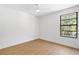 Bright bedroom with wood-look floors and natural light from a large window, ceiling fan at 8814 Hampden Dr, Tampa, FL 33626