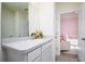 Bright bathroom with speckled countertop, white cabinets, and a view into the adjoining Bedroom at 9258 Rock Harbour Way, Tampa, FL 33637