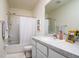 Well-lit bathroom featuring a shower with white tiling, a vanity, and neutral decor at 9258 Rock Harbour Way, Tampa, FL 33637