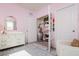 Bedroom with pink walls, a white changing table, and a closet with organized storage solutions at 9258 Rock Harbour Way, Tampa, FL 33637