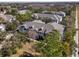 An aerial view of a townhome complex with mature trees and a community bench at 9510 Georgian Park Ln # 106, Tampa, FL 33626