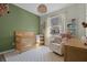 Charming Bedroom featuring a crib, rocking chair, and natural light, creating a cozy atmosphere at 9510 Georgian Park Ln # 106, Tampa, FL 33626