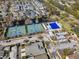 Aerial view of community tennis courts and a pool surrounded by lush greenery at 9510 Georgian Park Ln # 106, Tampa, FL 33626