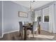 Bright dining room with a modern chandelier, and a dark wood table with seating for four at 9510 Georgian Park Ln # 106, Tampa, FL 33626