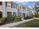 Charming townhome exterior with red shutters, a balcony, manicured landscaping, and a welcoming front entrance at 9510 Georgian Park Ln # 106, Tampa, FL 33626