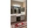 Bathroom featuring double vanity with white cabinets and mirrors, with red patterned rug at 116 Silver Falls Dr, Apollo Beach, FL 33572