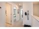 Hallway view with multiple doors, neutral paint, carpet, and a decorative hat hanging on the wall at 11828 Glenside Ter, Palmetto, FL 34221