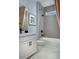 Well-lit bathroom featuring gray tiling, white marble floor and vanity, and modern black fixtures at 12233 New Tranquility Path, Venice, FL 34293