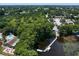 Aerial view of a lakefront community with mature trees, a pool, a pier, and boat slips for access to the water at 1227 Queen Anne Dr # C, Palm Harbor, FL 34684