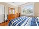 Sunlit bedroom with hardwood floors, a wooden dresser, and a peaceful view from the window at 123 17Th Se Ave, St Petersburg, FL 33701