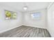 Bright bedroom featuring two windows and gray wood-look tile flooring at 1514 Sea Gull S Dr, St Petersburg, FL 33707