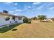 Grassy backyard featuring mature palm trees, small rock gardens and neighboring homes in a desirable community at 1531 Council Dr, Sun City Center, FL 33573