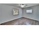 Bedroom featuring neutral paint, ceiling fan, sleek gray flooring, and two windows at 1531 Council Dr, Sun City Center, FL 33573