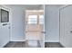 Hallway view with two doors and opening to a room with white tile flooring at 1531 Council Dr, Sun City Center, FL 33573