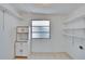 Bright storage room with window, shelves, cabinets, and neutral tile flooring at 1531 Council Dr, Sun City Center, FL 33573