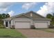 Charming single-story home featuring a three-car garage, stone accents, and a well-maintained lawn at 18483 Green Garden Ct, Venice, FL 34293