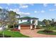 Stunning two-story home with green roof, brick driveway, lush landscaping, and a two-car garage at 1930 Kansas Ne Ave, St Petersburg, FL 33703