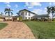 Charming curb appeal with a circular paver driveway and lush, manicured landscaping around this home's facade at 1930 Kansas Ne Ave, St Petersburg, FL 33703