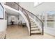 Bright foyer with a curved staircase and beautiful dark wood railings, creating an inviting entrance to the home at 1930 Kansas Ne Ave, St Petersburg, FL 33703