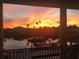 Balcony view of a colorful sunset reflecting on the water, near palm trees and waterfront homes at 1930 Kansas Ne Ave, St Petersburg, FL 33703