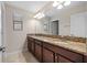 Bathroom featuring dual sinks with granite countertops and wood cabinets at 19429 Paddock View Dr, Tampa, FL 33647